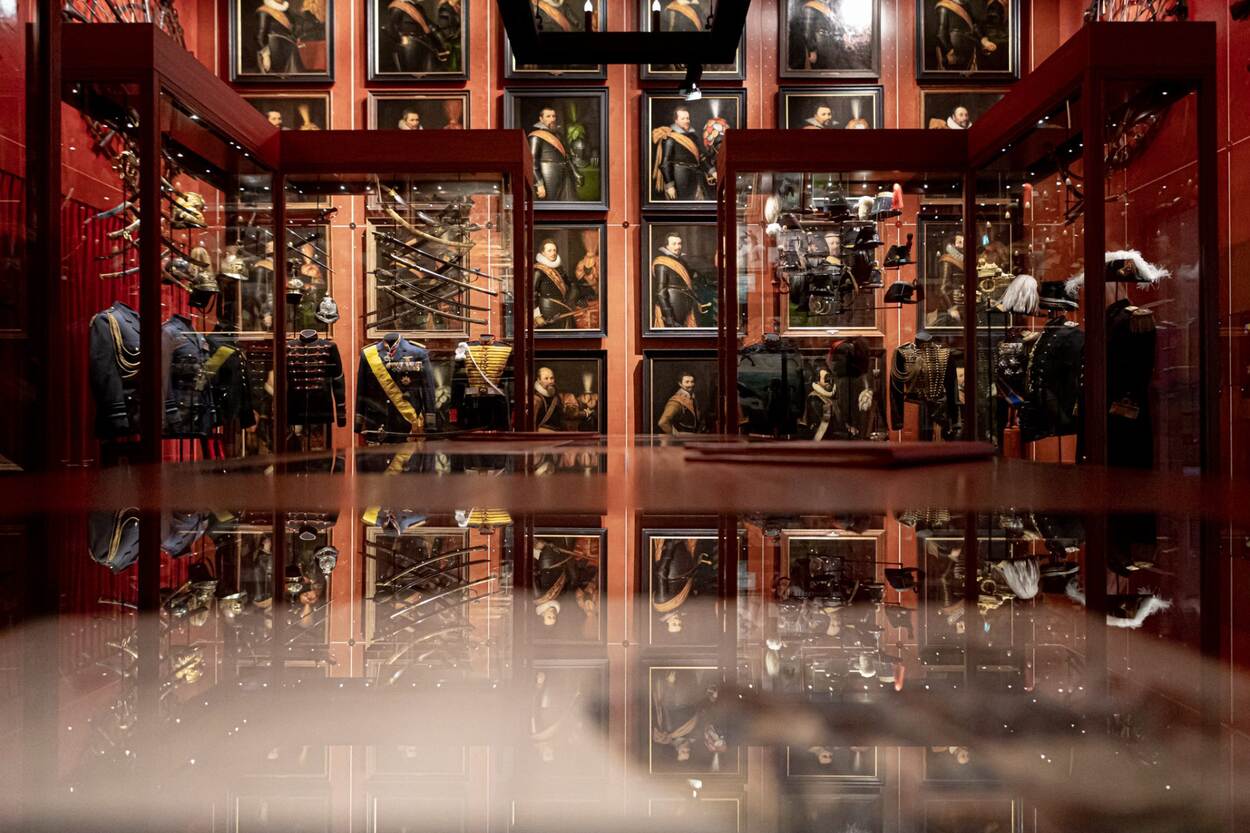 Een ruimte in Museum Bronbeek vol vitrines vol sabels en krissen, met op de achtergrond tientallen schilderijen.