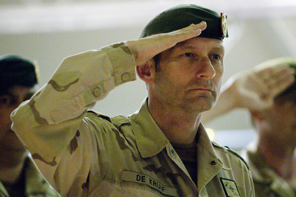 De Kruif in zijn jongere jaren in ‘desert’ gevechtstenue met baret op, salueert.