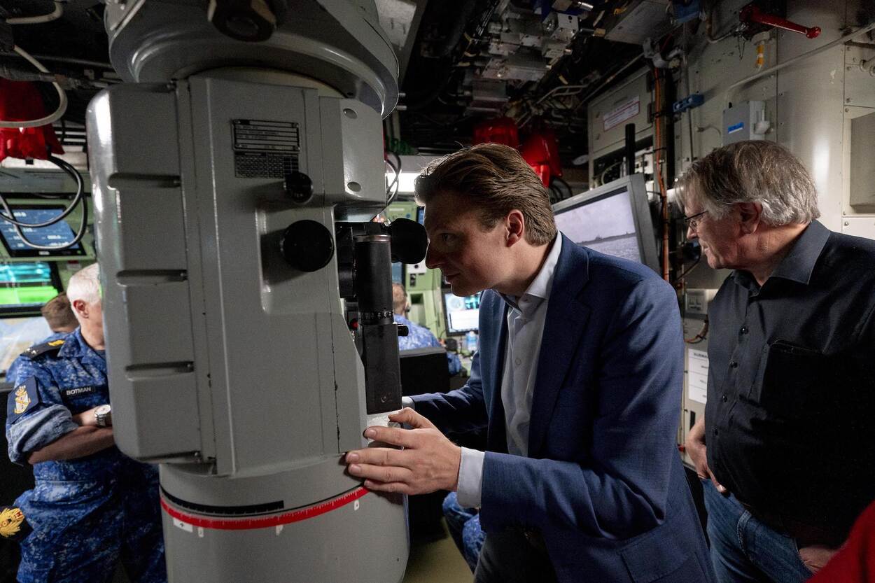 De minister kijkt door de periscoop van een onderzeeboot.