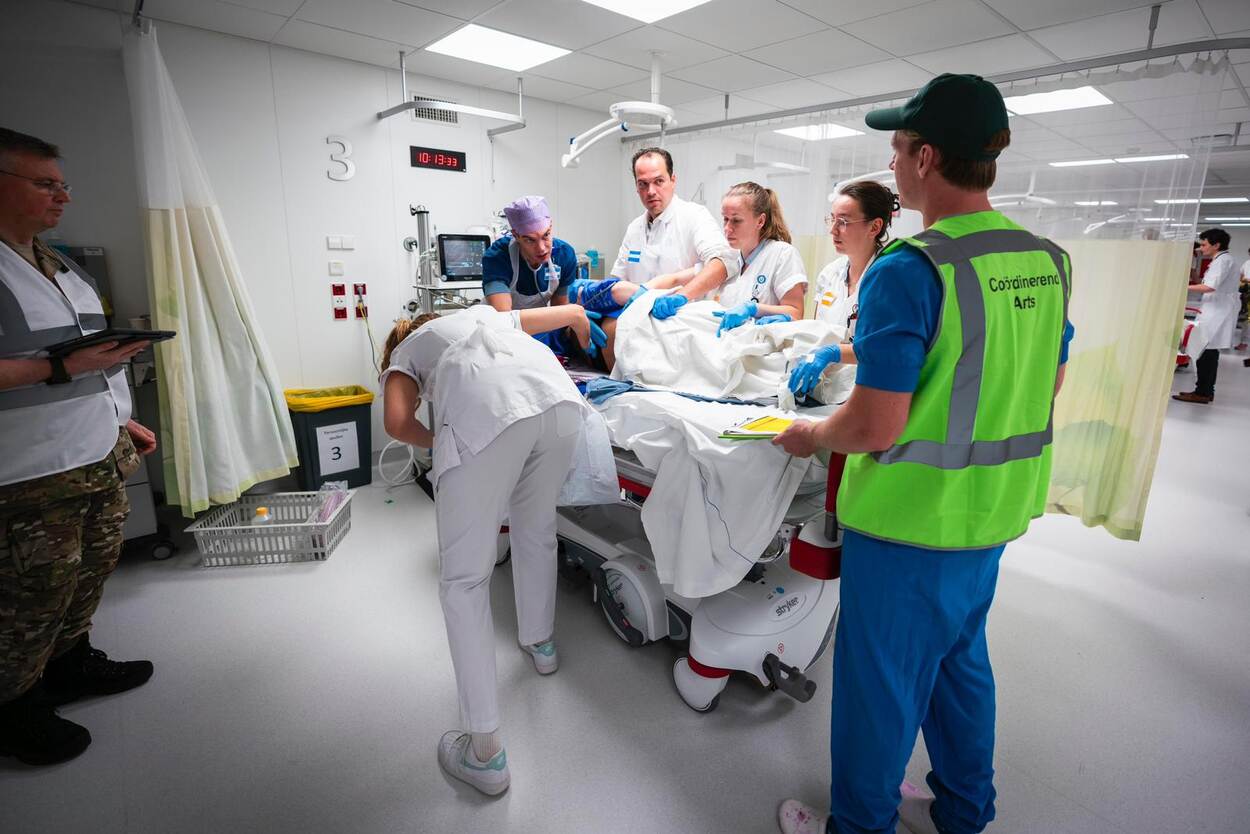 Verschillende hulpverleners staan rond een ziekenhuisbed in het Calamiteitenhospitaal. Op het bed ligt patiënt met fictieve verwondingen.