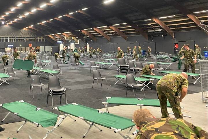 reservisten zetten in een sporthal bedjes in elkaar.