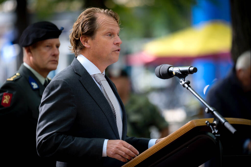 Gijs Tuinman houdt een toespraak met een militair in zijn kielzog