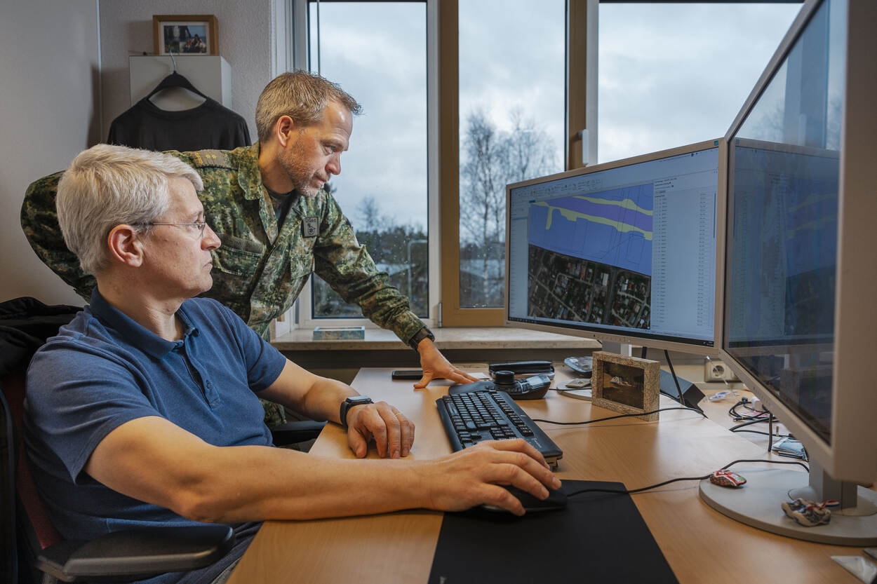 Twee medewerkers van DGeo kijken op een beeldscherm naar een van de door DGeo gemaakte kaarten.