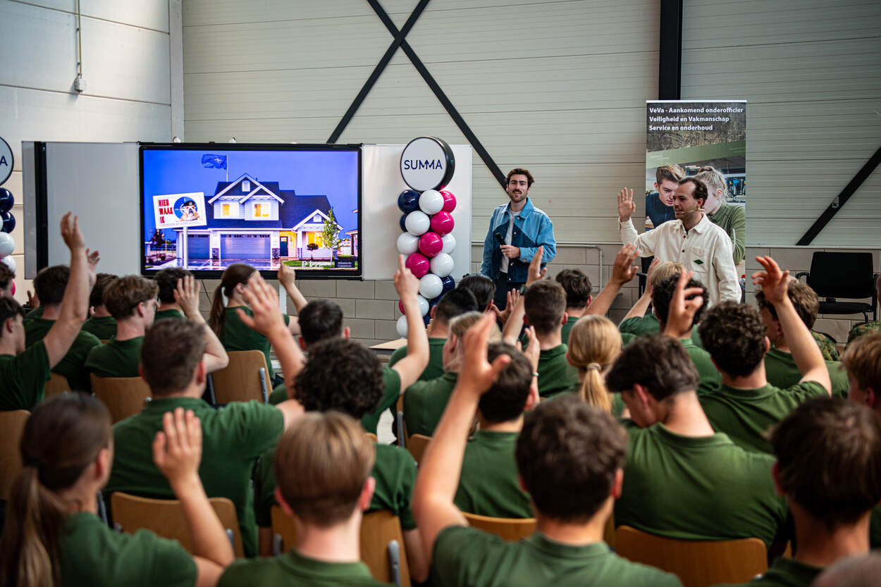 Studenten steken hand op na vraag van presentatoren.