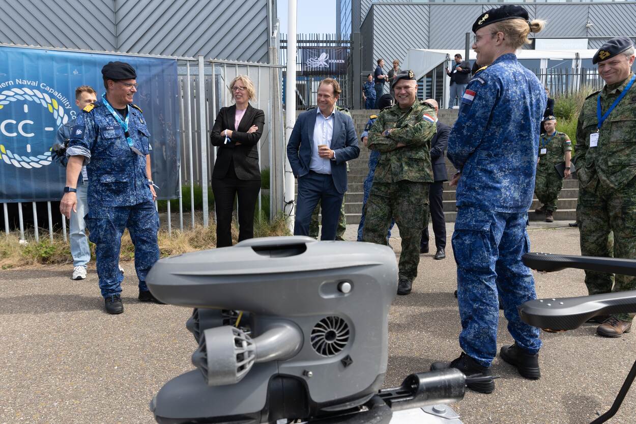 Militairen en burgers bekijken onderwatersysteem.