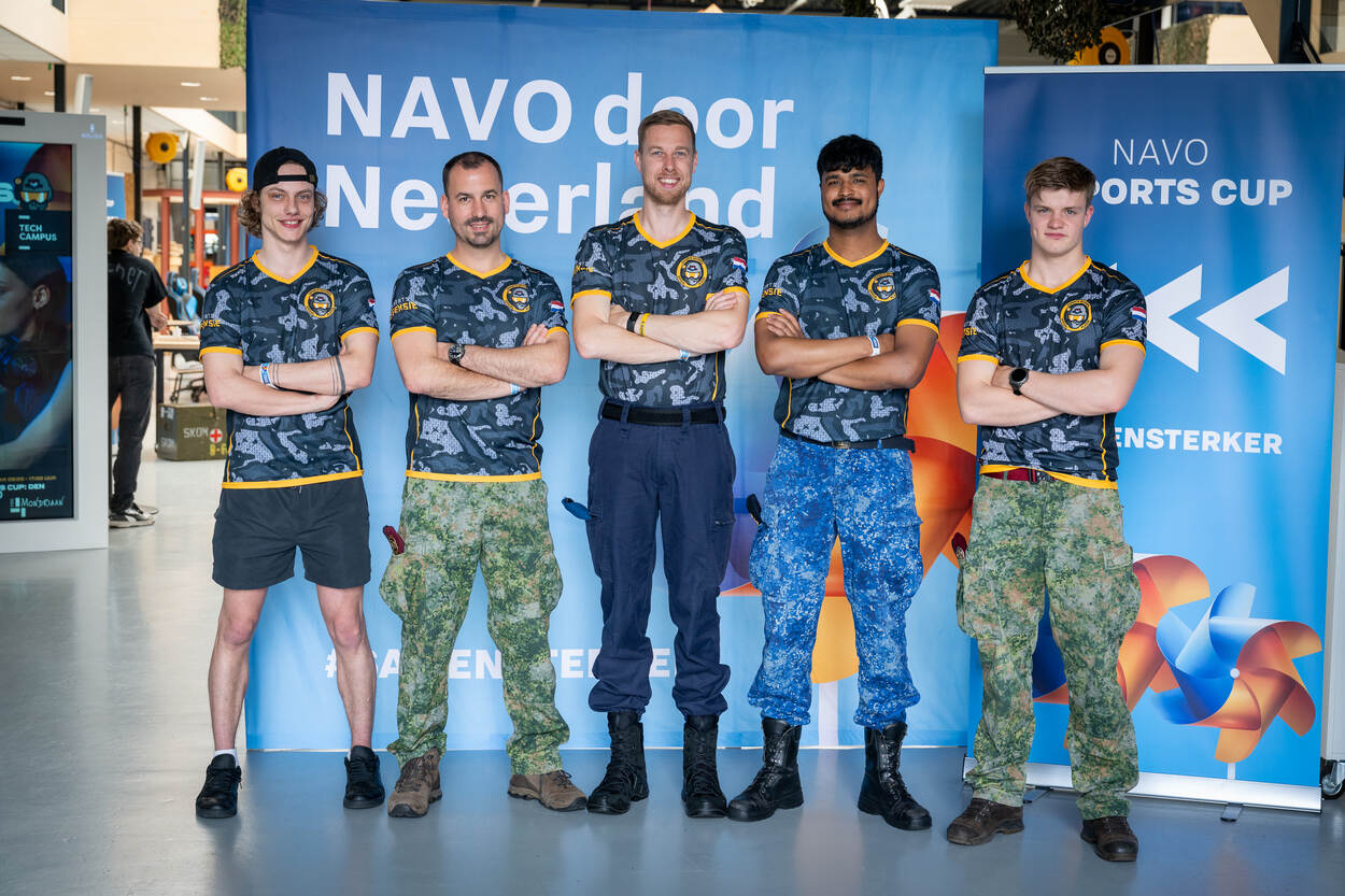 5 militairen staan naast elkaar met de armen over elkaar.