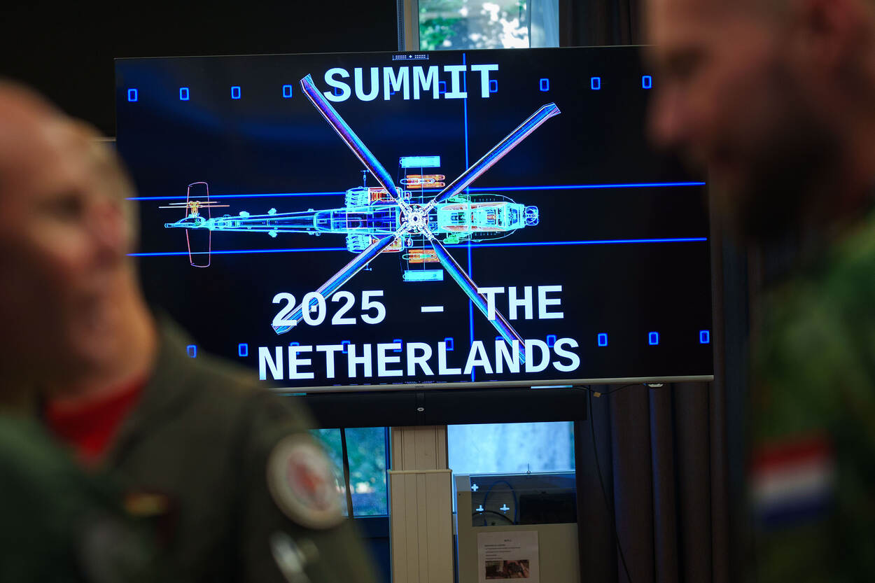 Een beeldscherm met daarop een blauwdruk van een Apache en de tekst ‘Summit 2025 – The Netherlands’.