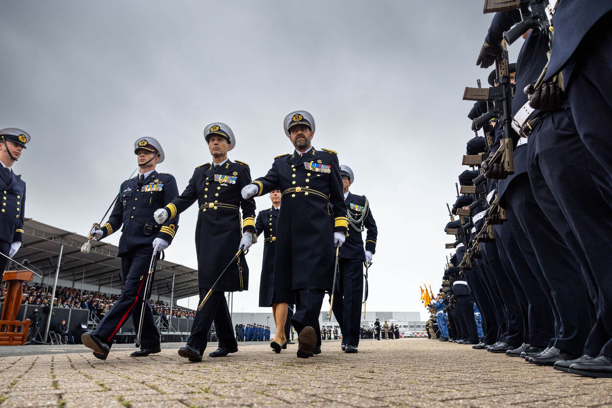 Drie hoge militairen wandelen richting een ceremonie