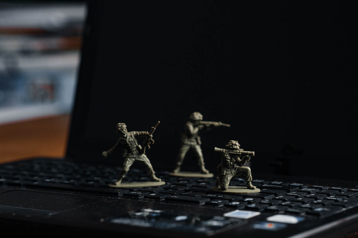 Drie speelgoedsoldaatjes op het toetsenbord van ene laptop.