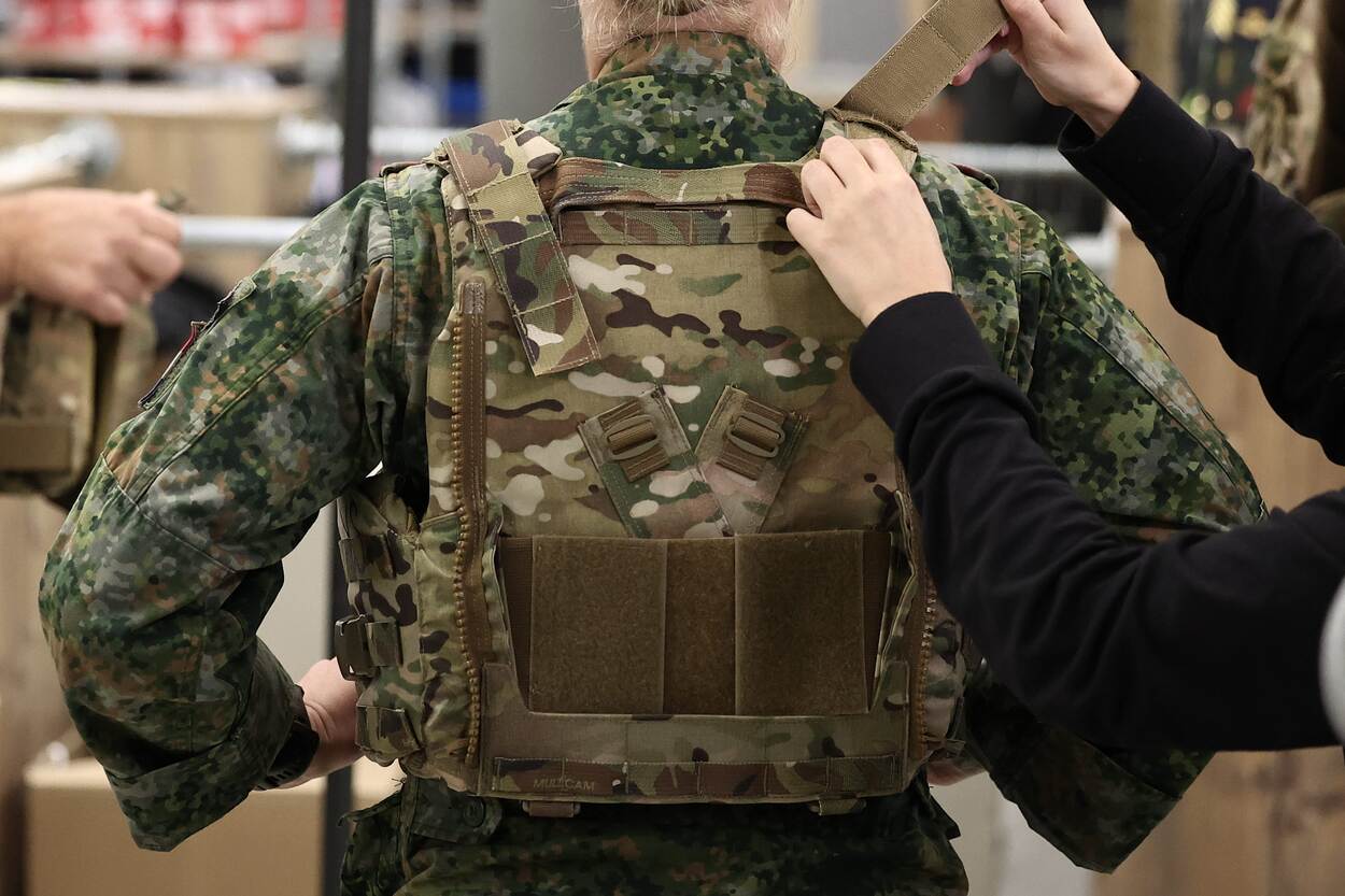 Een vrouwelijke militair krijgt een kogel- en scherfwerend vest voor vrouwen aangemeten.