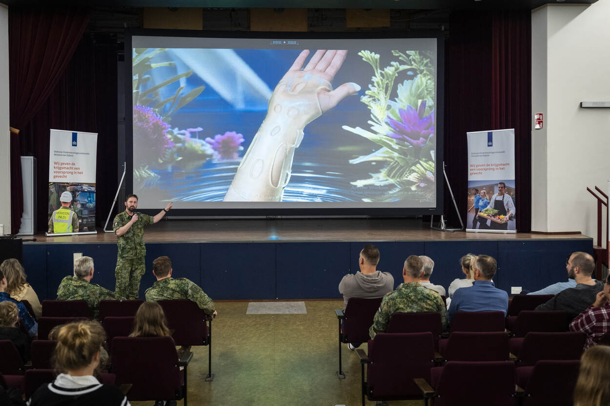 Militair spreekt zaal toe tijdens presentatie