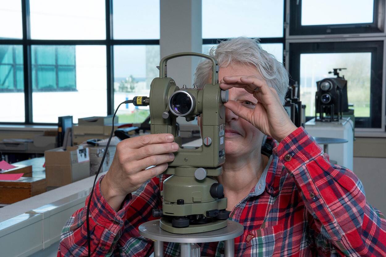 Een medewerker stelt een theodoliet af.