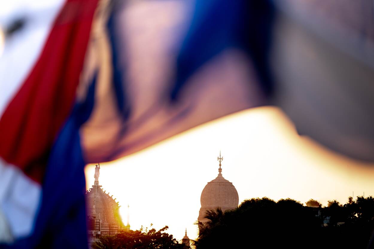 Tegen de achtergrond van een tempel gefotografeerd marinepersoneel in tropenwit.