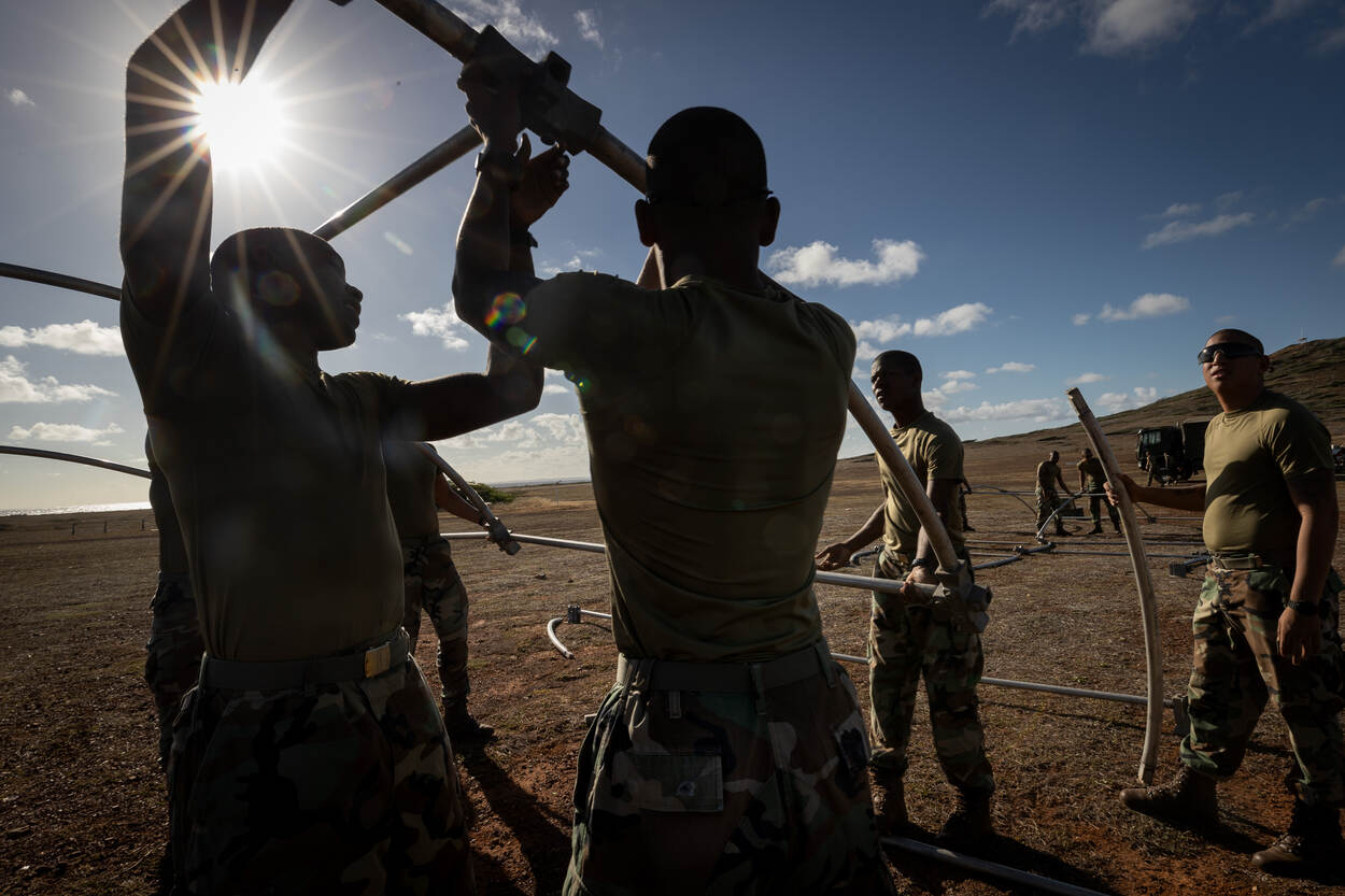 Caribische militairen bouwen een tent op.