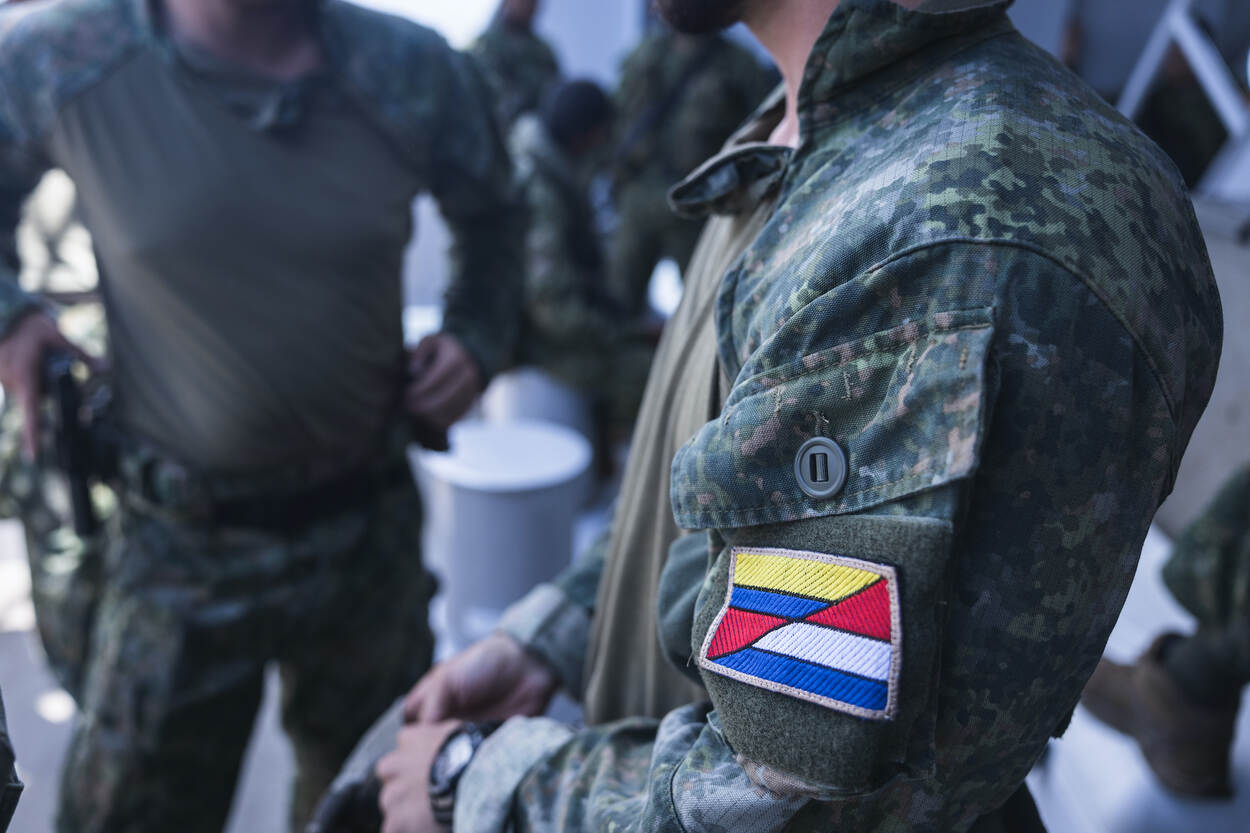 Een mouwembleem waarin de Nederlandse en Colombiaanse vlag in elkaar overvloeien.