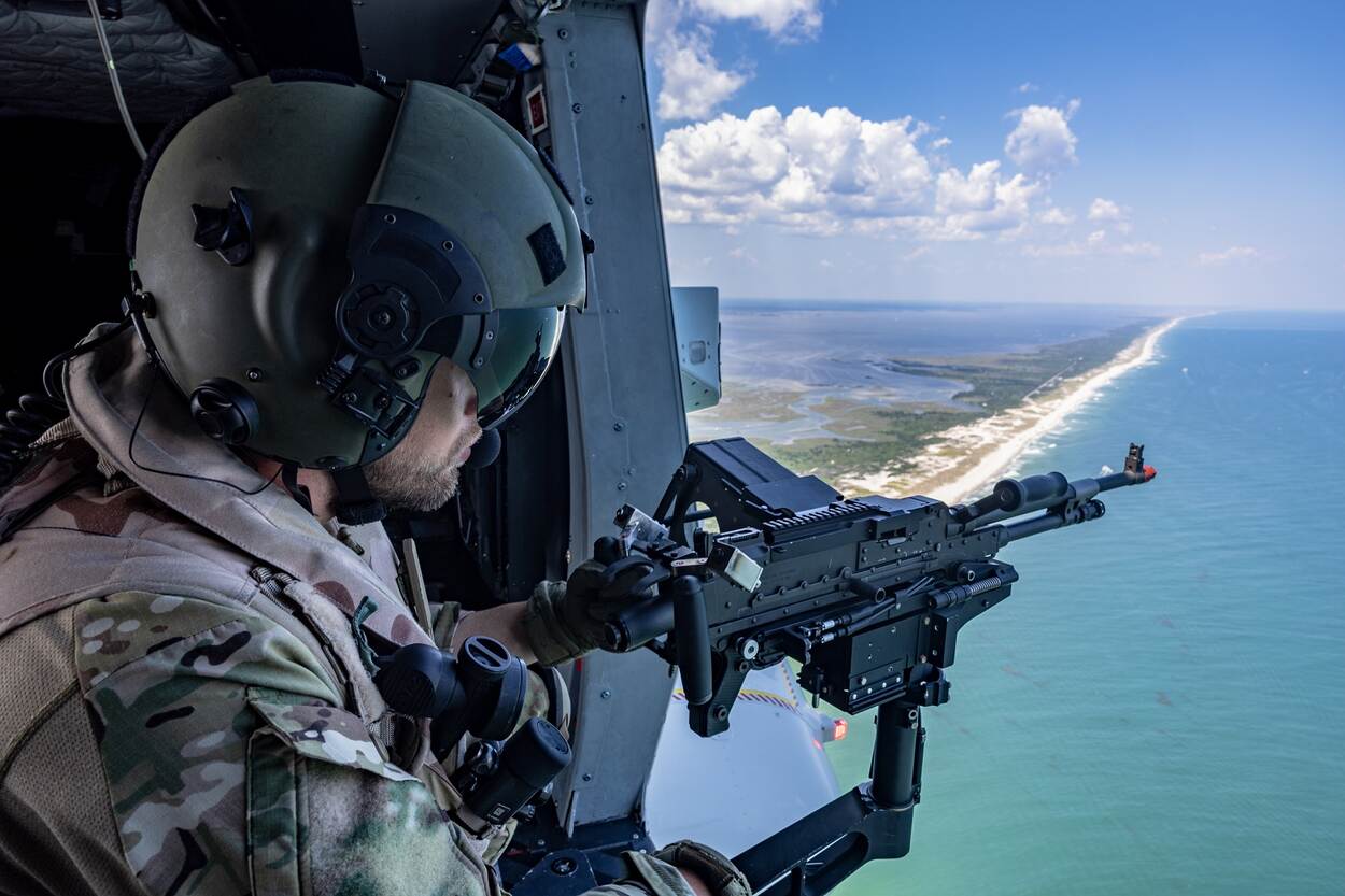 Een NH90 met doorgunner nadert de kust.
