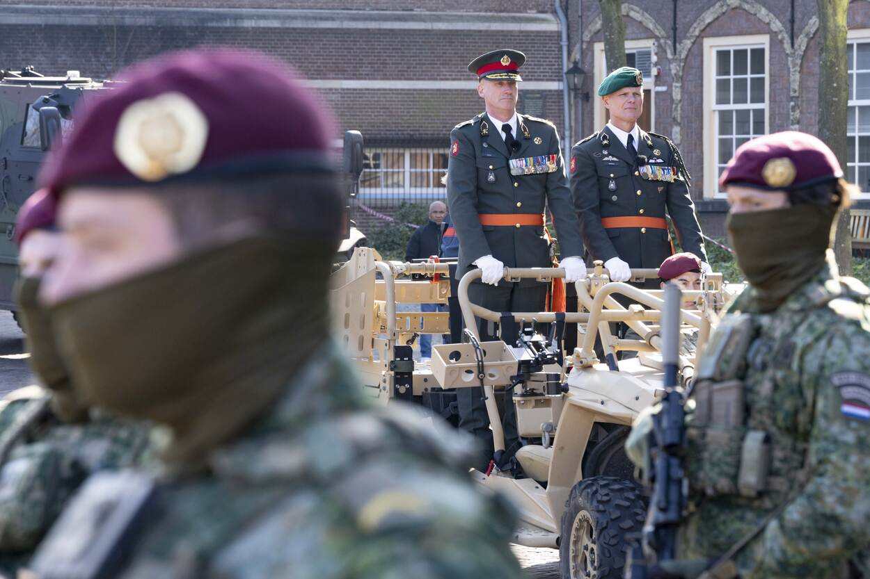 Twee generaals staan in een militair voertuig en kijken naar voren.