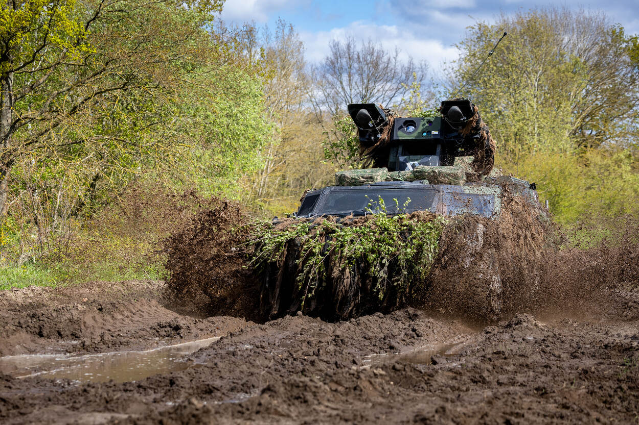 Een Stinger Weapon Platform Fennek rijdt door het modderige oefenterrein in het Duitse Guz  Altmark.