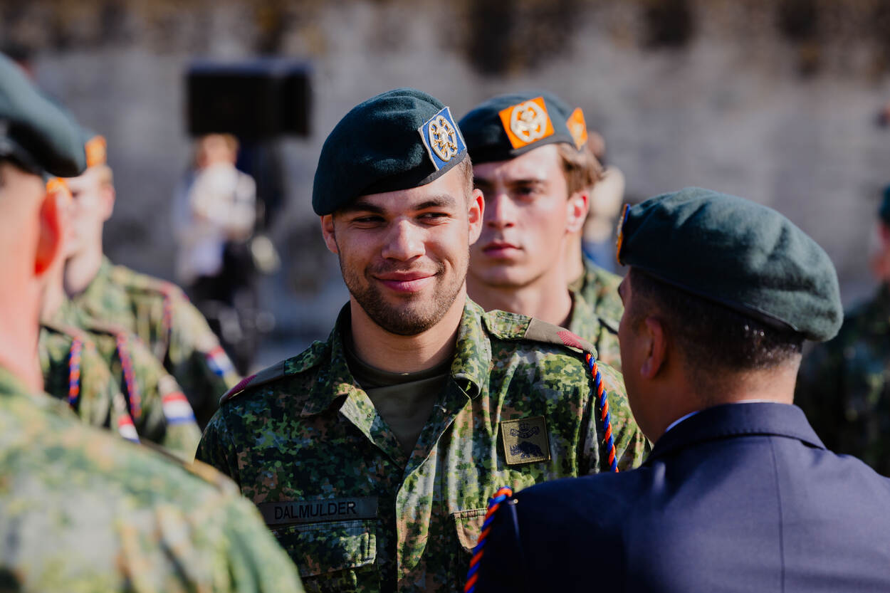 Een lachende, jonge fuselier neemt zijn koord in ontvangst.