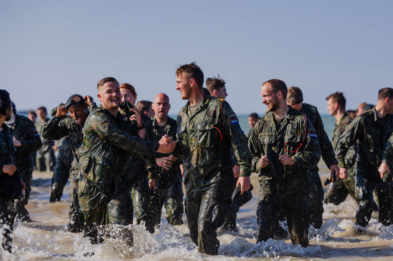 Fuseliers zijn zojuist de zee in gerend en lachen naar elkaar met een nat pak.