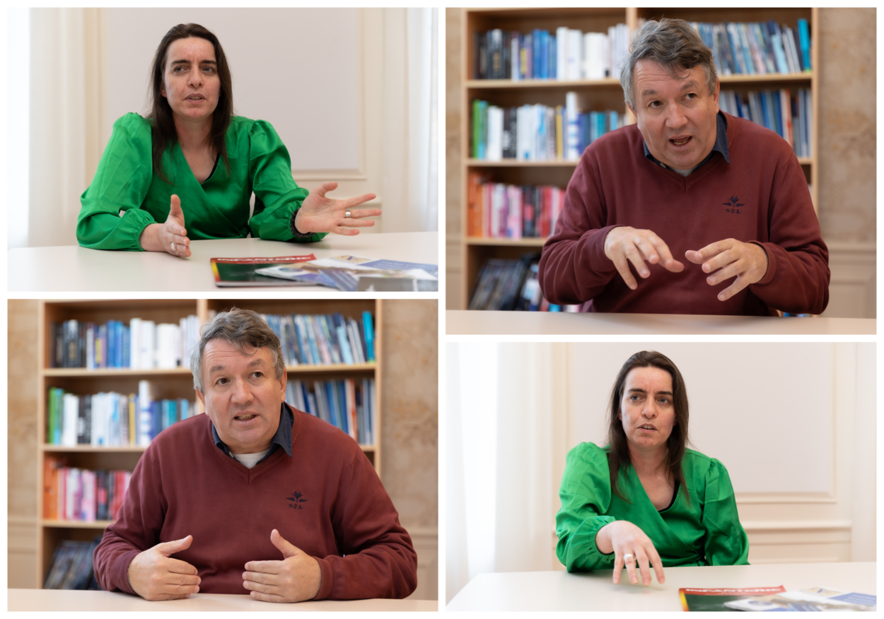 Smeenk en De Spiegeleire praten terwijl ze aan een tafel zitten. Daarbij maken ze gebruik van hun handen om uitleg te geven.