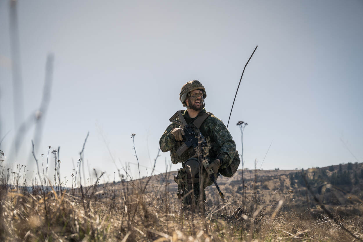 Een militair beweegt zich voort over het terrein.