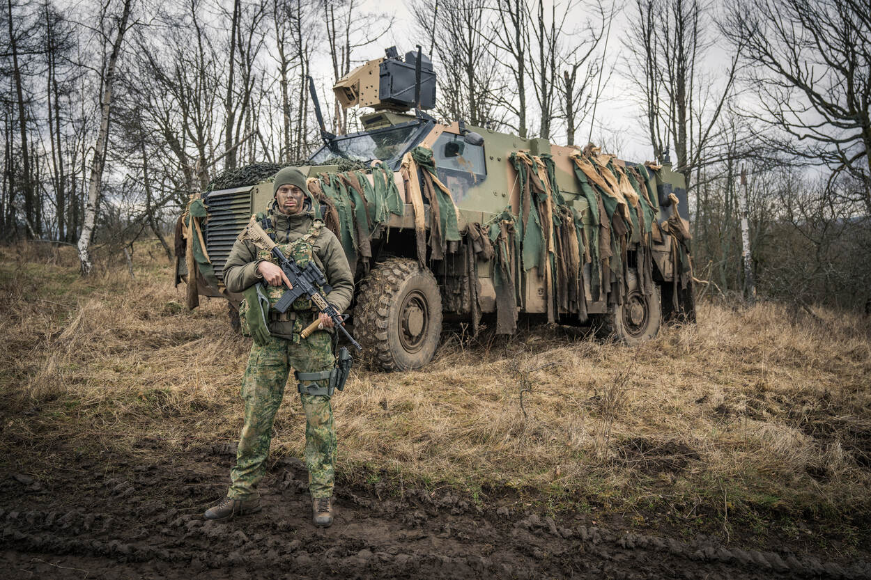 Bushmaster Chauffeur Bart poseert voor zijn voertuig.