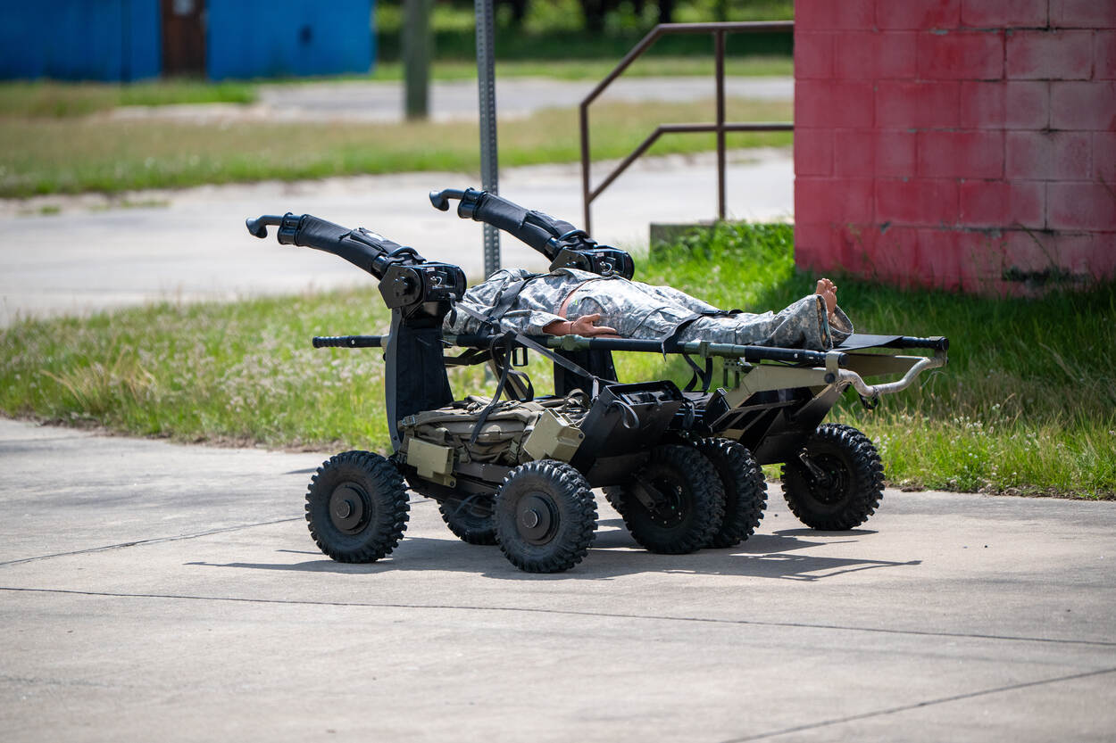 Links: een witte drone op de grond, met daaronder een rood 3D-geprint explosief.