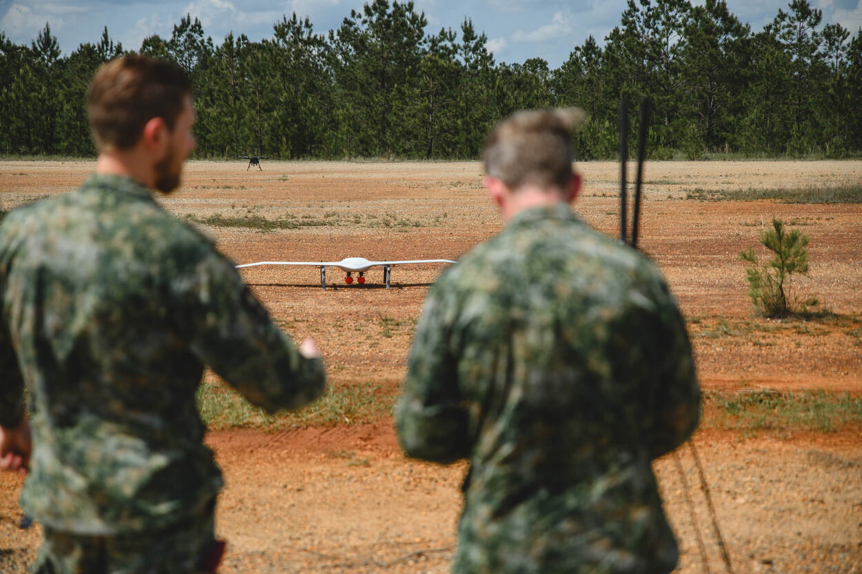 Links: een witte drone op de grond, met daaronder een rood 3D-geprint explosief.