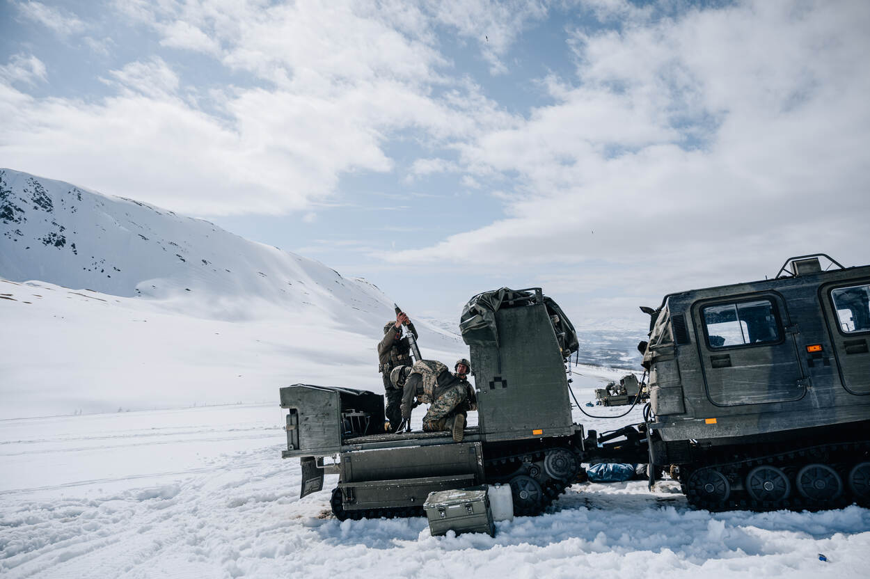 Mariniers van 81mm lanceren een mortier in de sneeuw.