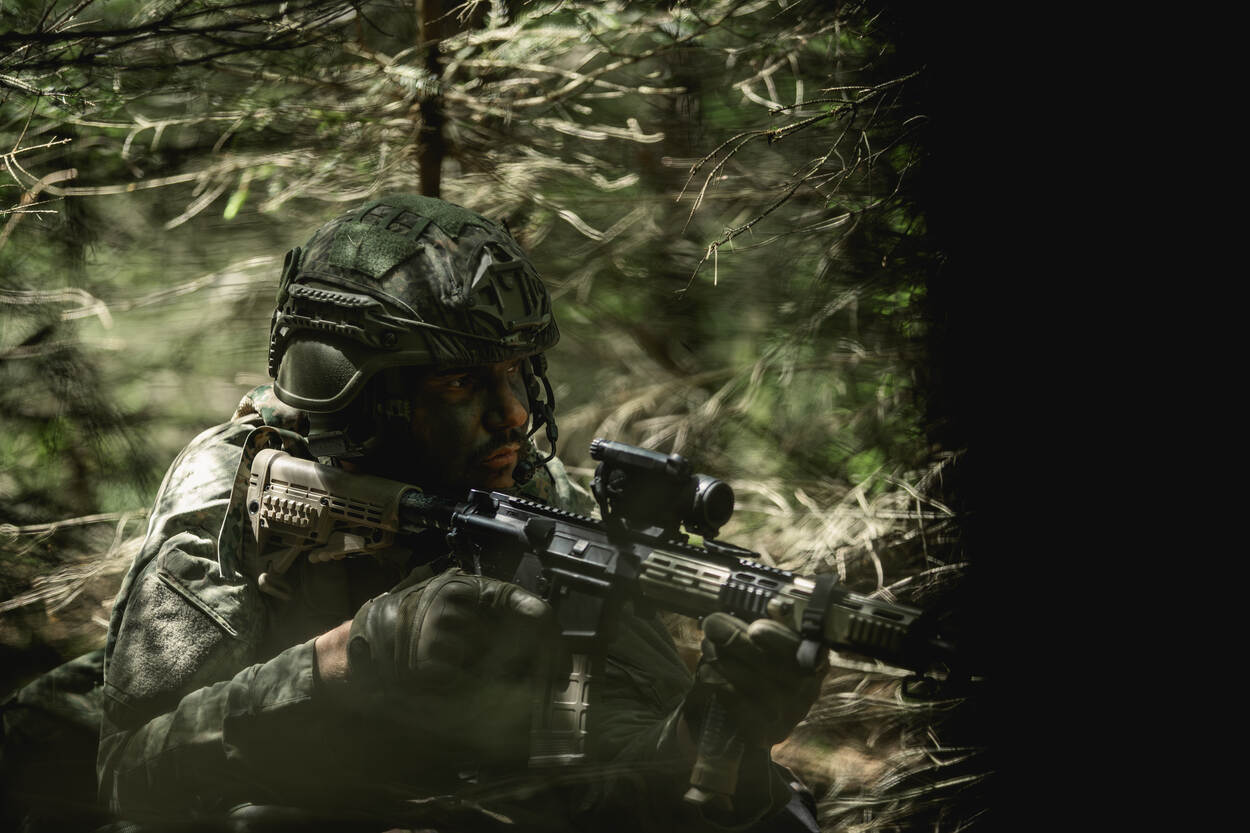 Een militair richt zijn wapen.