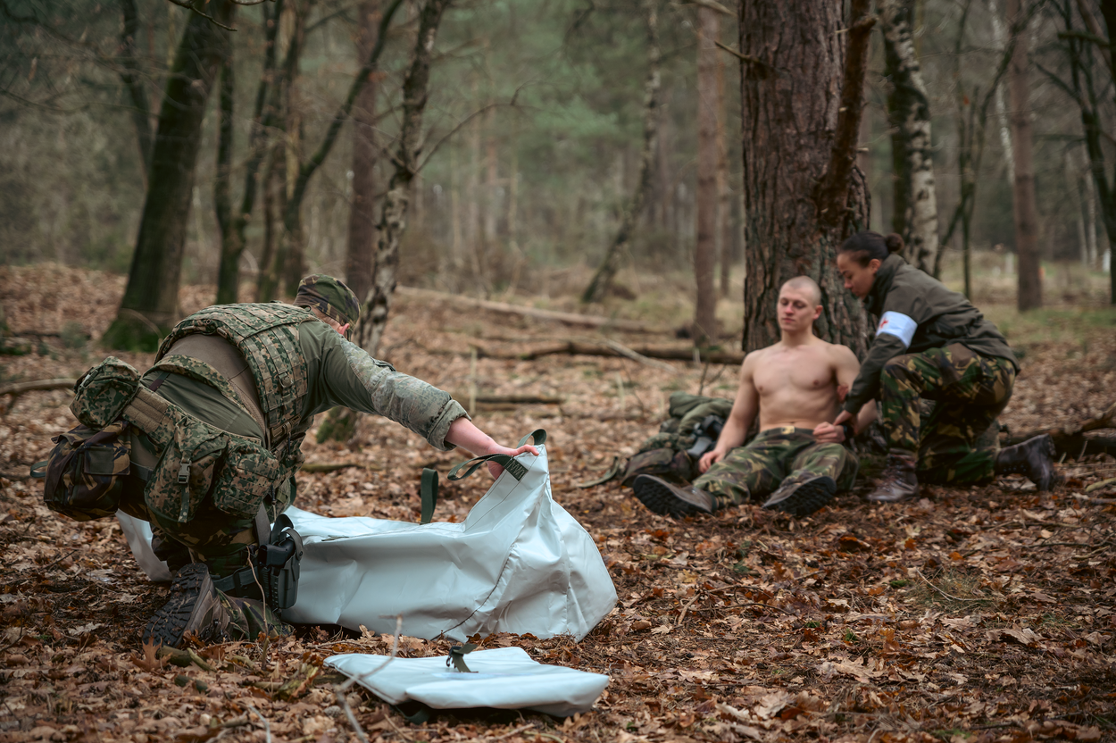 Een militair zit tegen een boom.