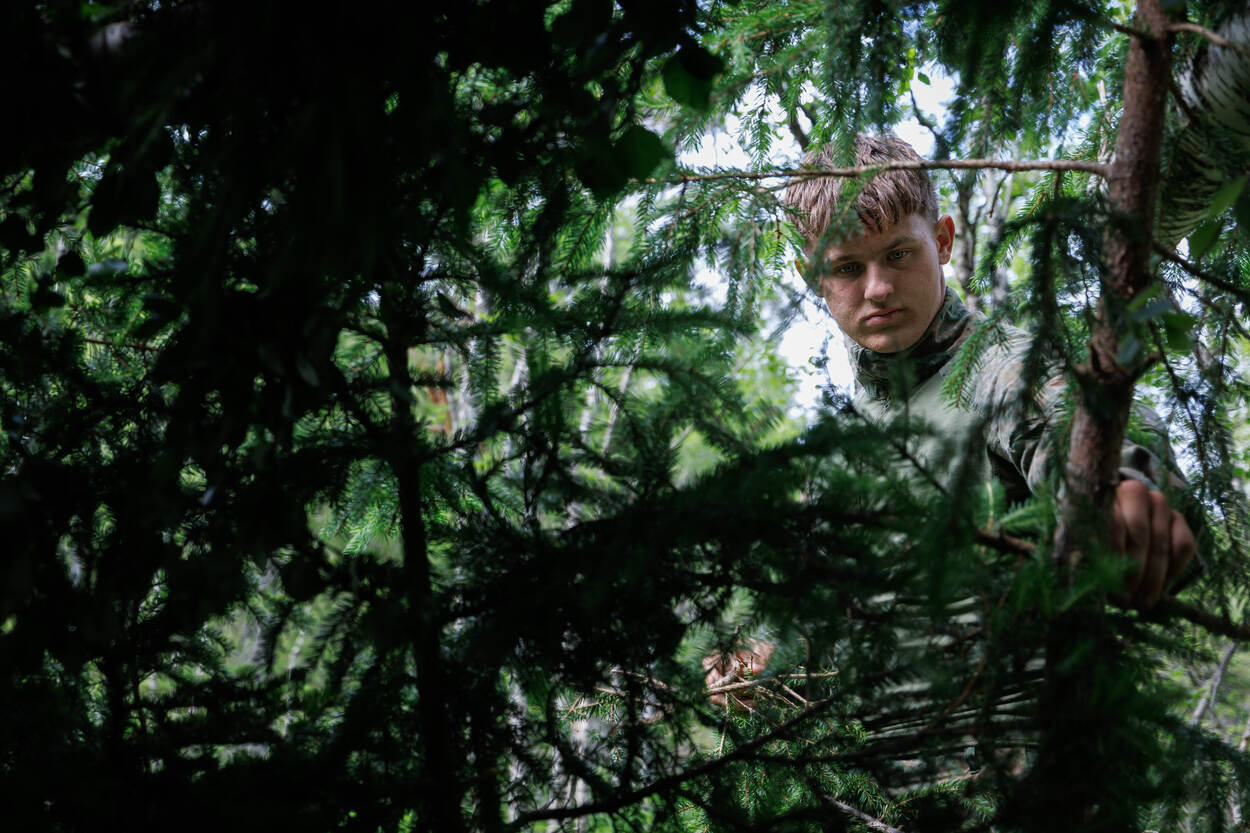 Militair bouwt dak van onderkomen.