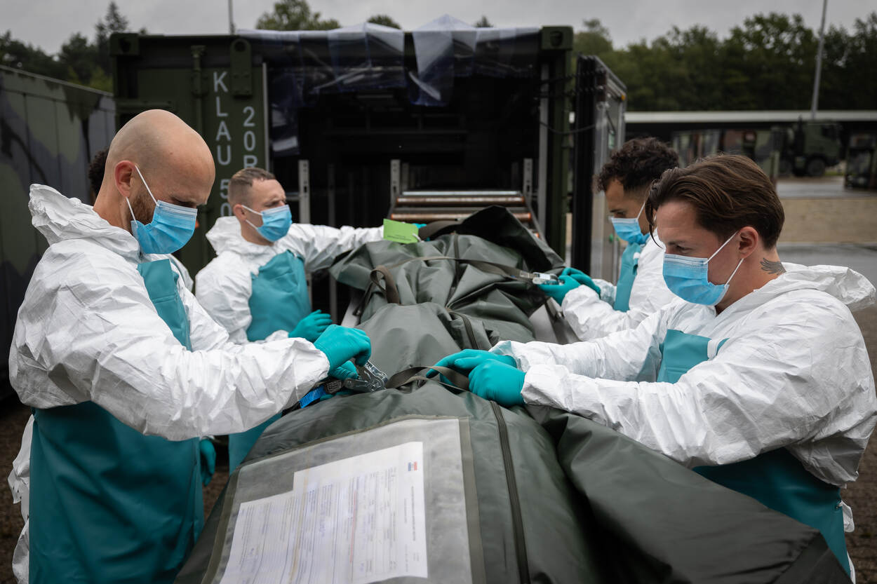 Vier militairen bij een lijkzak.