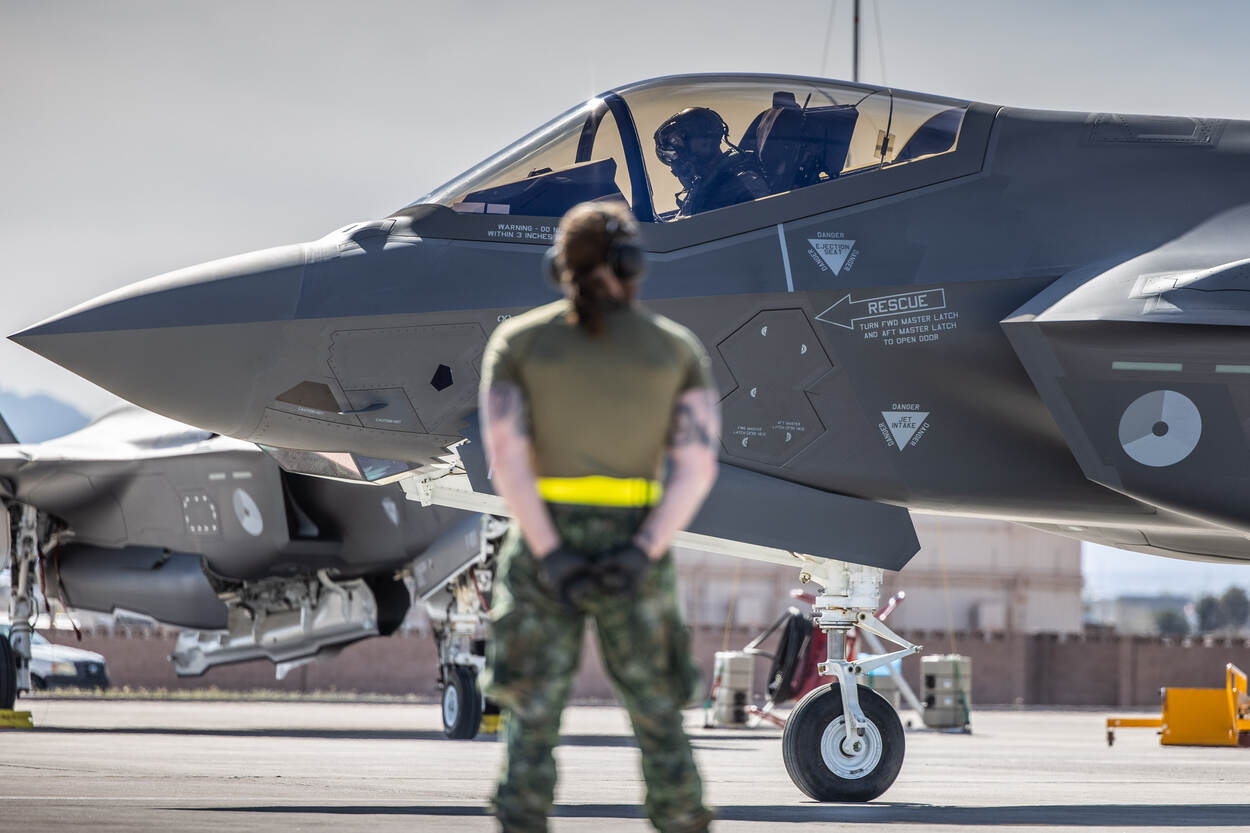 een crewchief kijkt toe wanneer een F-35 weg taxiet