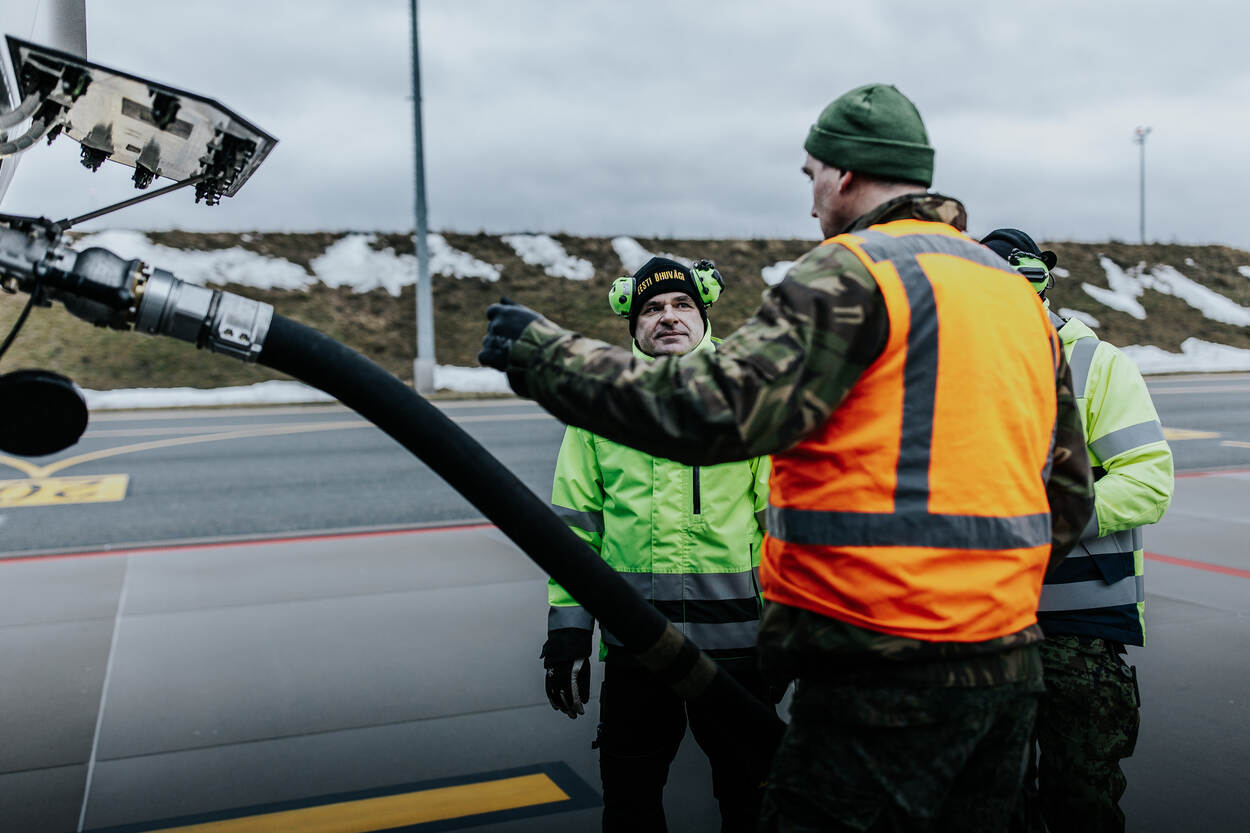 Een Nederlandse monteur tankt samen met twee Estse een F-35 bij.