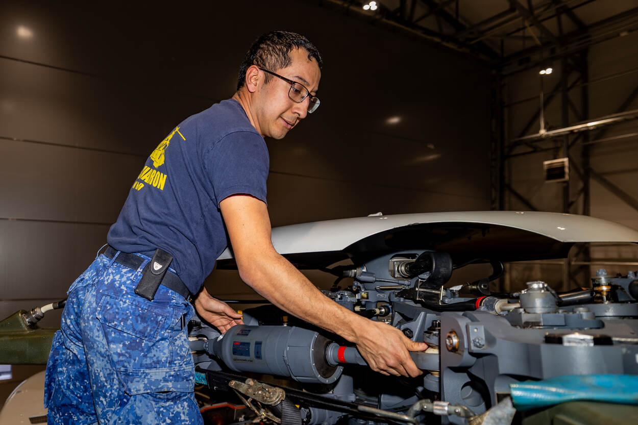 Een technicus werkt aan een NH90