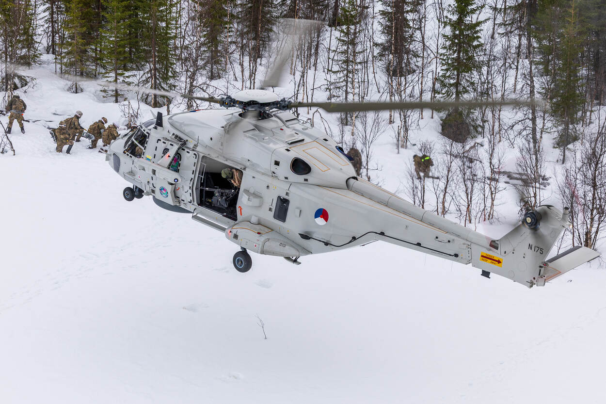 Een NH90 landt in een winters landschap.