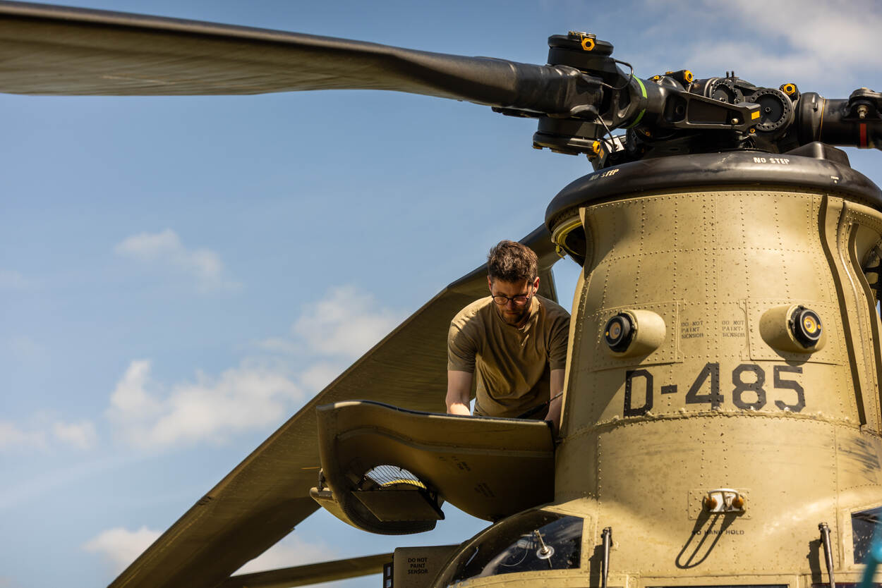 Monteur aan het werk bij de rotorbladen van een Chinook.