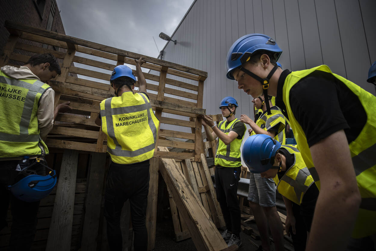 De demonstranten werpen een barricade op met palets.