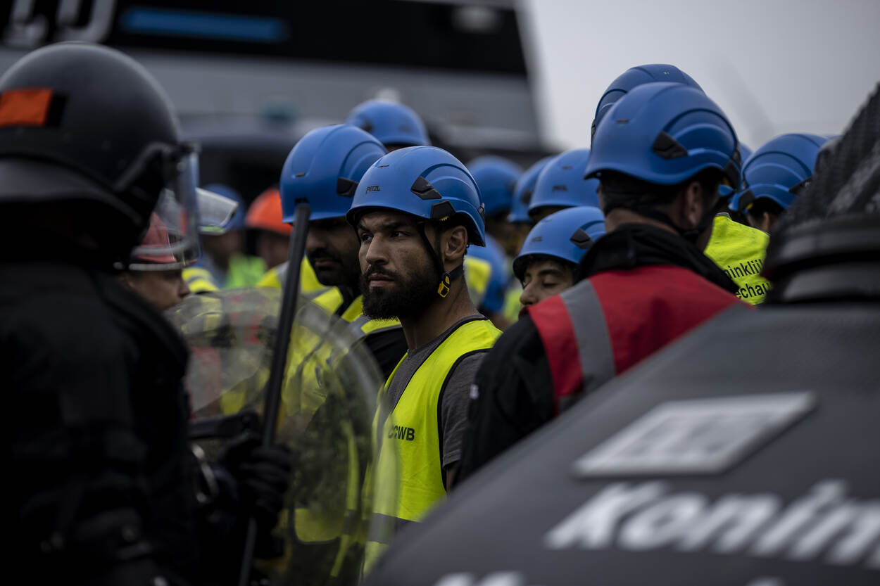 Een demonstrant staat heel dichtbij de ME, die op linie staat.