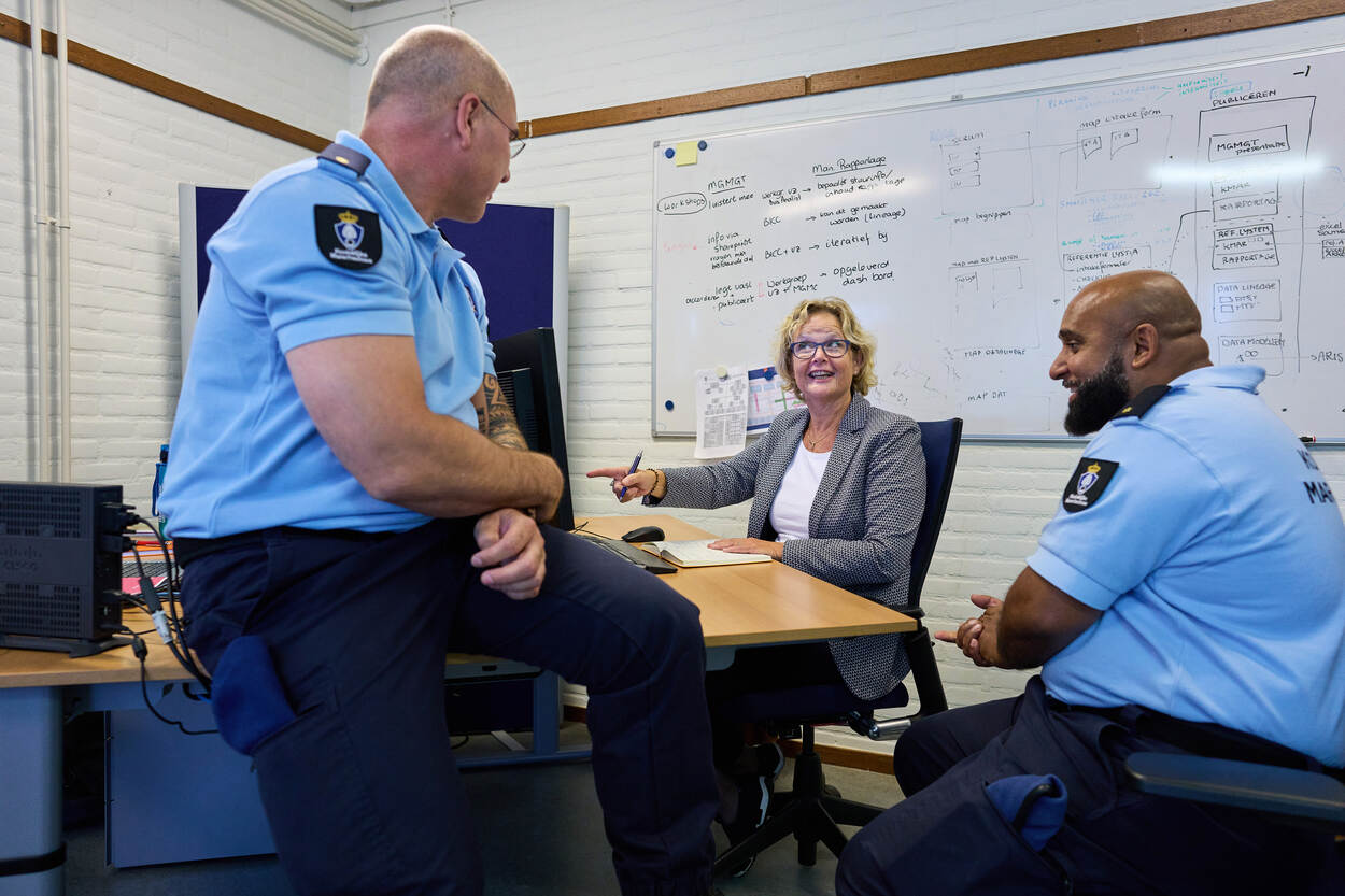 3 collega's van de afdeling Metagegevens Management overleggen op kantoor.