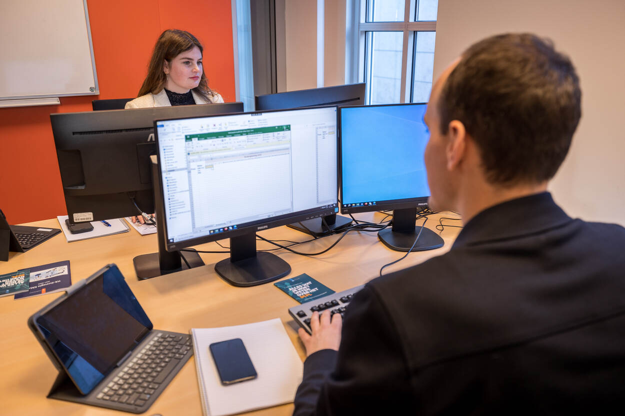 Medewerkers van het Bureau Bijzondere Instroom op hun werkplek achter de computer.
