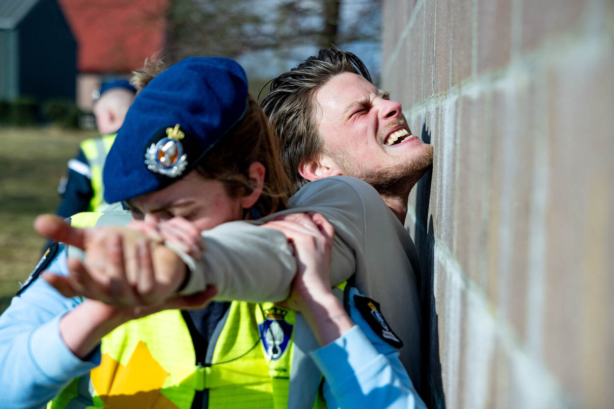 Een verdachte die tegen een muur wordt aangehouden, gaat op in zijn rol en schreeuwt het uit.