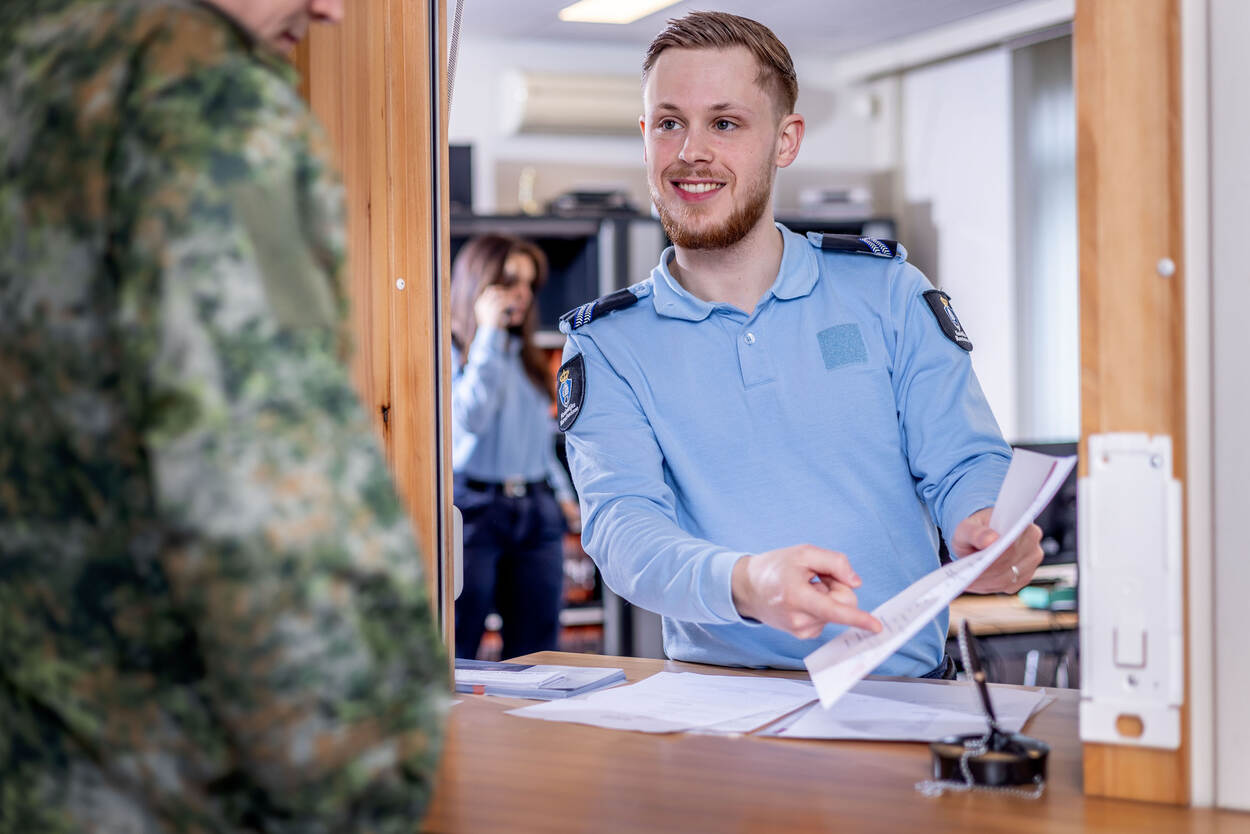 Marechaussee-1 Rossi helpt een Duitse militair aan de balie van het Kmar-kantoor.