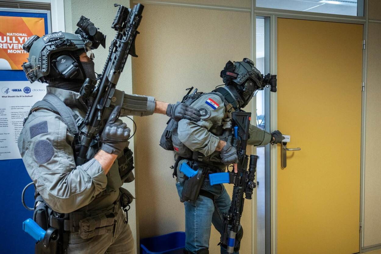 Twee leden van de Dienst Speciale Interventies oefenen in vol ornaat het doorzoeken van een gebouw.