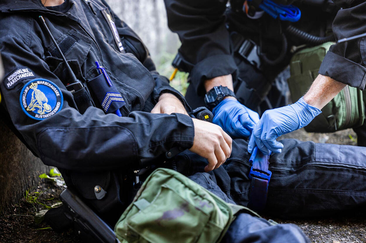 Tijdens een oefening wordt een tourniquet aangebracht bij een gewonde collega.