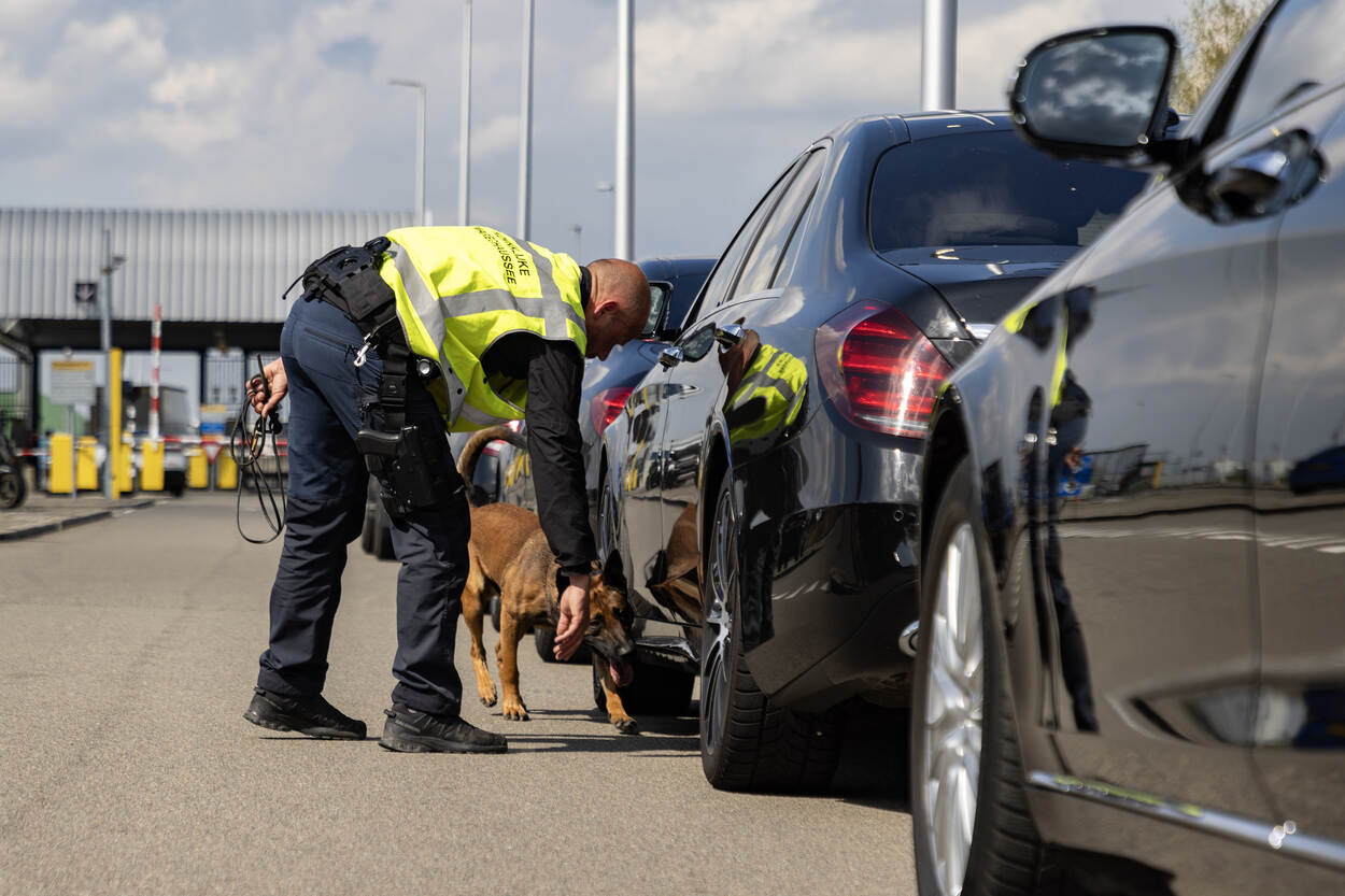 Speurhond van KMar controleert voertuig.
