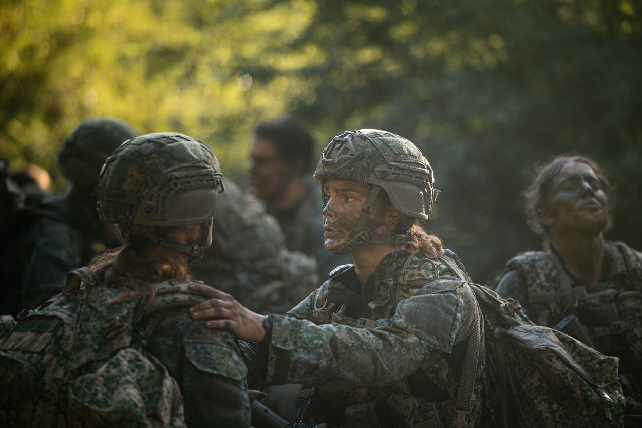 Deelnemers praten elkaar moed in voordat ze de poort binnenlopen.