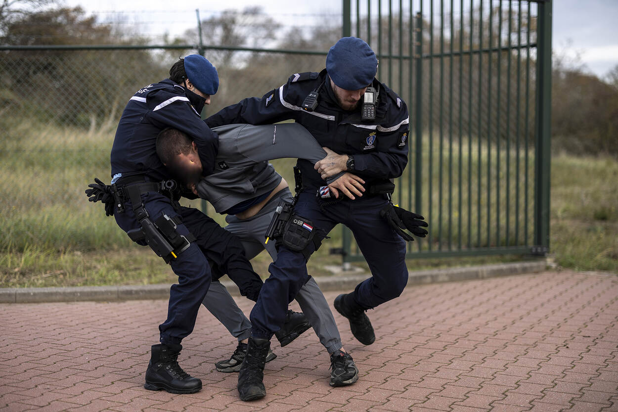 Twee marechaussees proberen een indringer onder controle te krijgen